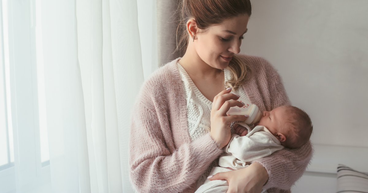 Mother feeding a bottle to an infant.